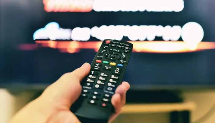 Primer plano de un mando a distancia apuntando a un televisor